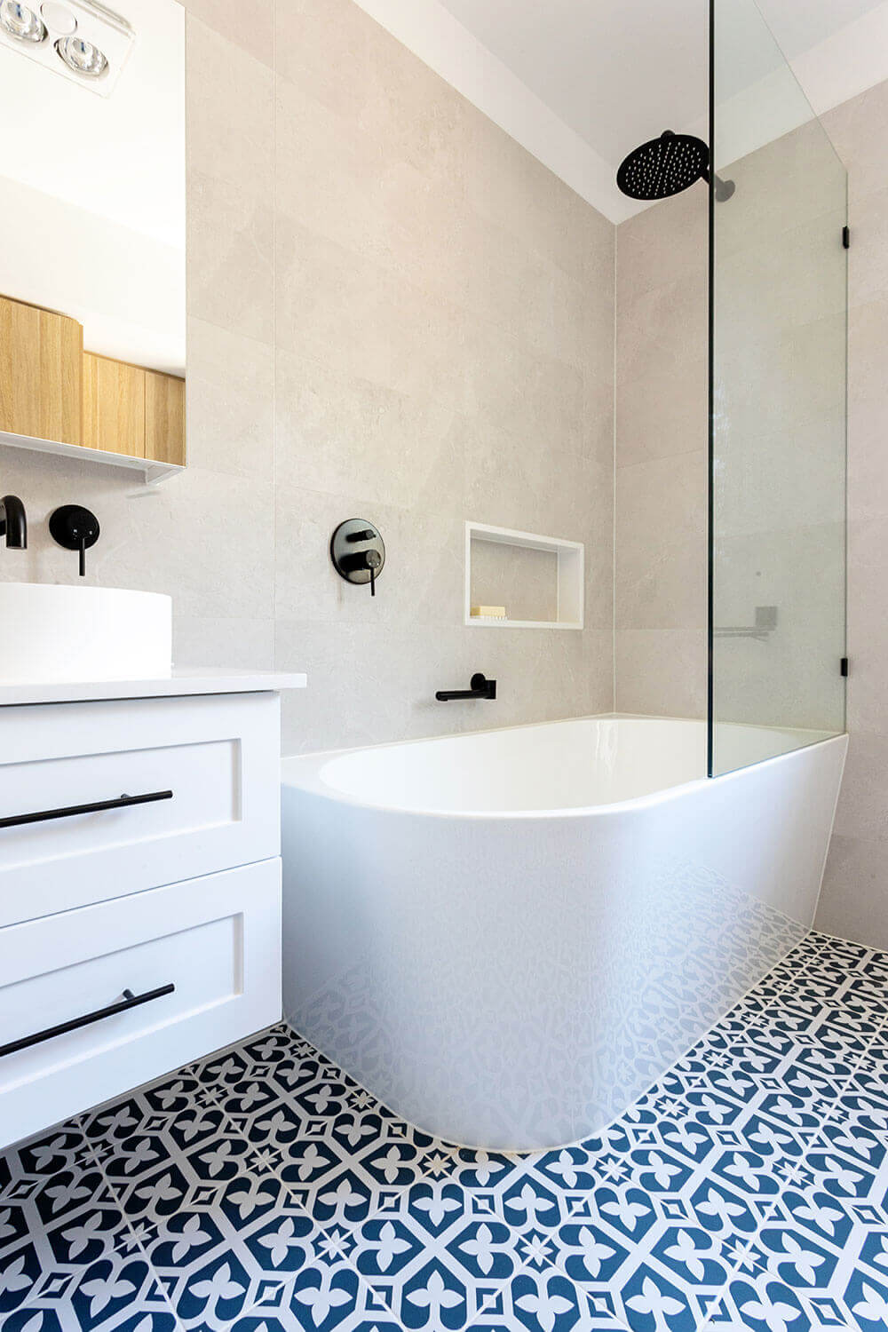 A bathroom with a blue and white tiled floor that requires home renovation.