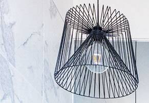 A pendant light hanging from a marble wall during a home renovation.
