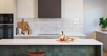 A kitchen with a wooden counter top and green tiled walls.
